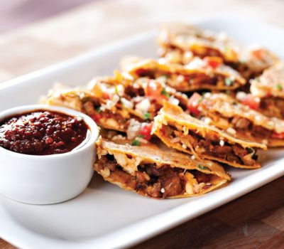 The Pork Quesadillas are crispy corn tortillas wrapped around Perry’s Famous pork chop that has been enhanced with smoky flavors of Guajillo, roasted vegetables, cilantro and cotija cheese.